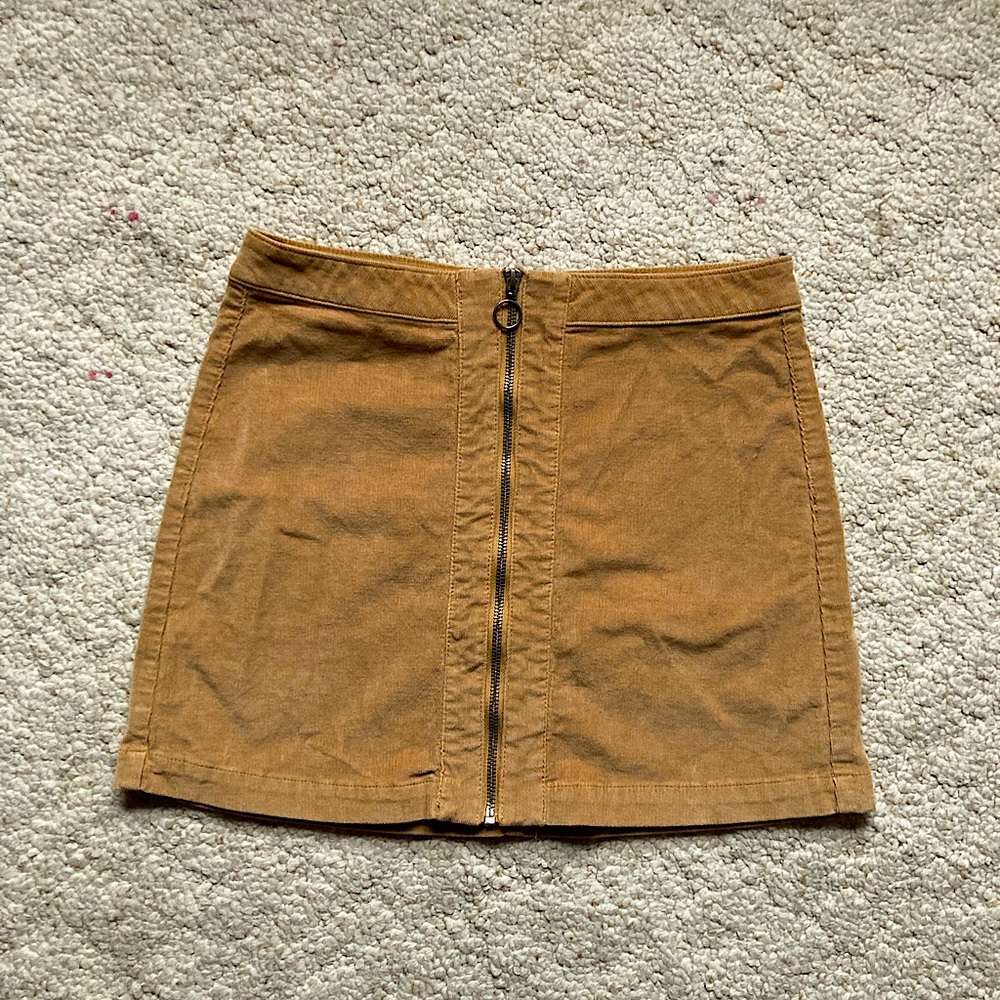 Tan mini skirt with functional zipper at the front. Runs small